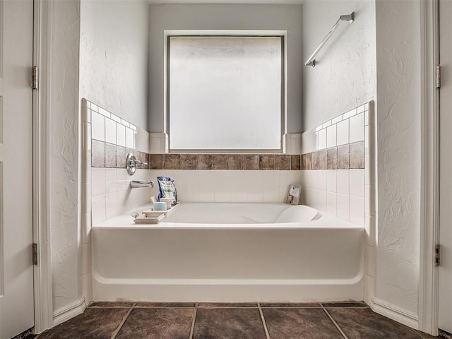 5112 NW 163rd St, Edmond, OK 73013 - bathroom with a textured wall, a bath, and tile patterned floors