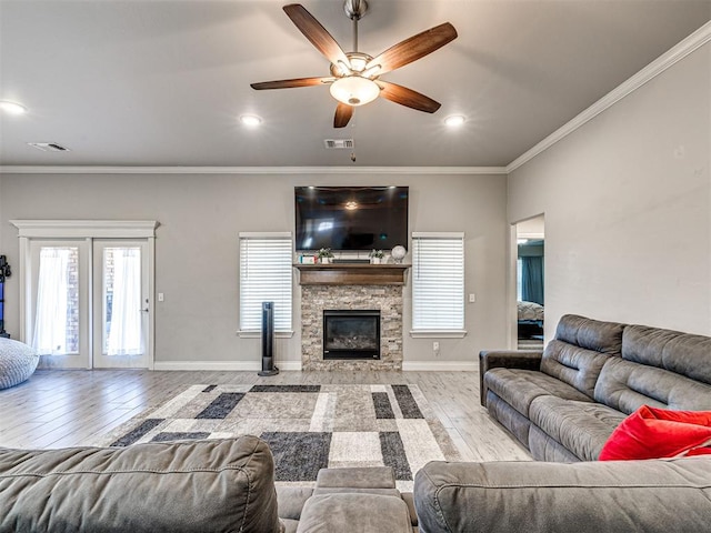 917 NE 34th Ter, Moore, OK 73160 - living room featuring wood finished floors, a ceiling fan, a stone fireplace, ornamental molding, and recessed lighting