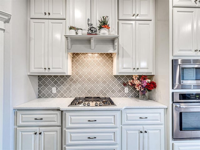 917 NE 34th Ter, Moore, OK 73160 - kitchen featuring stainless steel appliances, white cabinets, decorative backsplash, and light stone countertops