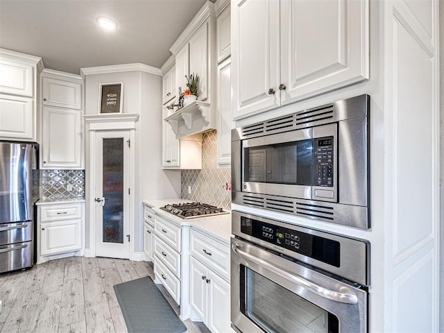 917 NE 34th Ter, Moore, OK 73160 - kitchen featuring stainless steel appliances, light countertops, white cabinetry, light wood finished floors, and recessed lighting