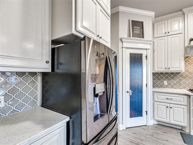 917 NE 34th Ter, Moore, OK 73160 - kitchen featuring stainless steel fridge, white cabinets, backsplash, light stone countertops, and ornamental molding