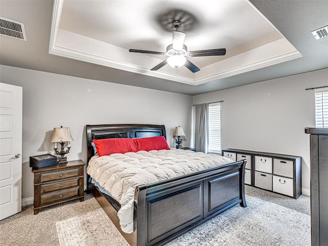 917 NE 34th Ter, Moore, OK 73160 - bedroom featuring a tray ceiling, multiple windows, light carpet, and a ceiling fan