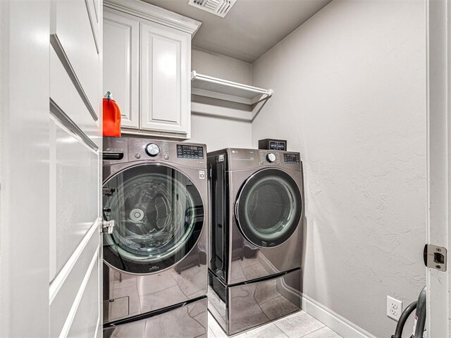 917 NE 34th Ter, Moore, OK 73160 - laundry area featuring cabinet space and washing machine and clothes dryer