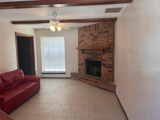 8300 NW 10th St Unit 140, Oklahoma City, OK 73127 - tiled living room with a textured wall, a brick fireplace, ceiling fan, and a textured ceiling