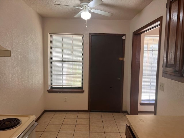 8300 NW 10th St Unit 140, Oklahoma City, OK 73127 - entrance foyer featuring a ceiling fan, plenty of natural light, light tile patterned floors, and a textured ceiling