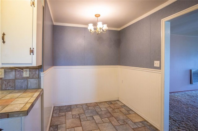 423 N Missouri St, Weatherford, OK 73669 - unfurnished dining area with a chandelier, a wainscoted wall, stone finish floors, and crown molding