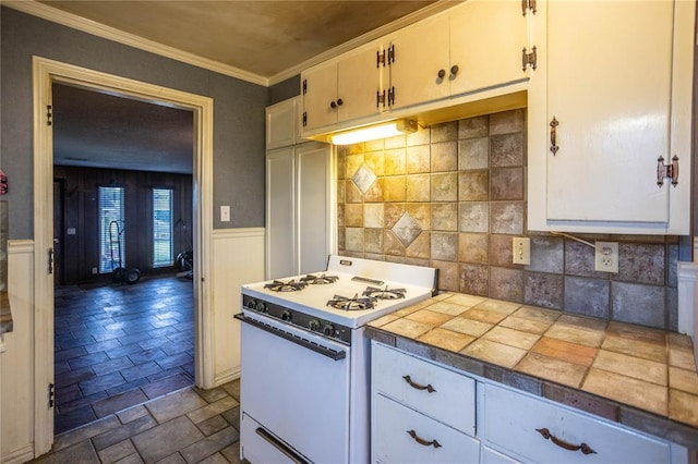 423 N Missouri St, Weatherford, OK 73669 - kitchen featuring white range with gas stovetop, stone tile floors, tile counters, crown molding, and white cabinets