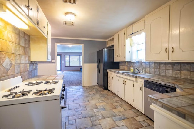 423 N Missouri St, Weatherford, OK 73669 - kitchen featuring gas range gas stove, dishwasher, black fridge, plenty of natural light, and a wainscoted wall