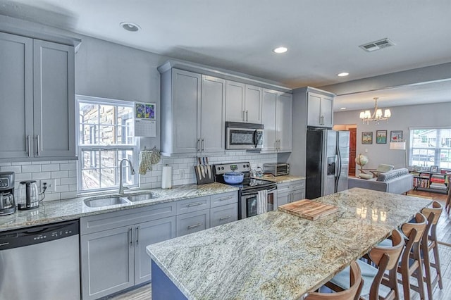 1621 NW 18th St, Oklahoma City, OK 73106 - kitchen with stainless steel appliances, gray cabinetry, recessed lighting, a chandelier, and a kitchen island