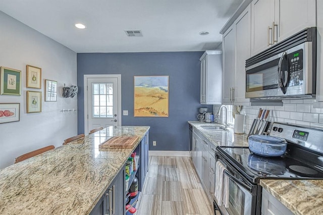 1621 NW 18th St, Oklahoma City, OK 73106 - kitchen featuring appliances with stainless steel finishes, light stone countertops, recessed lighting, and tasteful backsplash