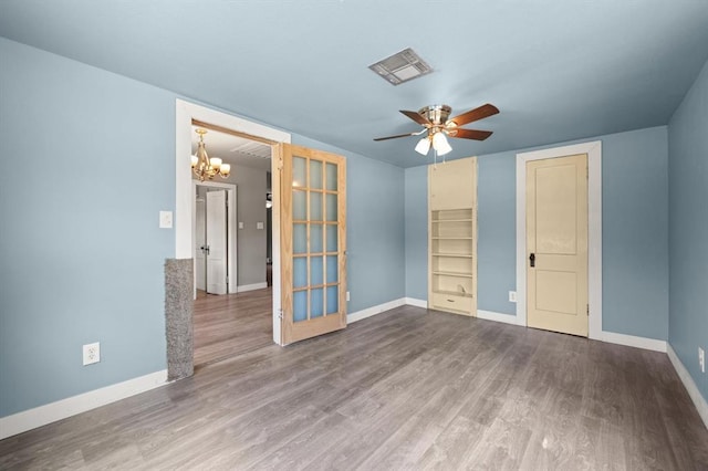 4504 N Grove Ave, Warr Acres, OK 73122 - unfurnished room featuring wood finished floors, a chandelier, and a ceiling fan