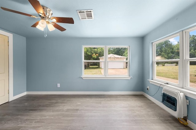 4504 N Grove Ave, Warr Acres, OK 73122 - interior space featuring a ceiling fan, heating unit, plenty of natural light, and wood finished floors