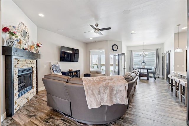 12505 Shady Gln, Choctaw, OK 73020 - living room featuring wood finished floors, a ceiling fan, a fireplace, a chandelier, and recessed lighting