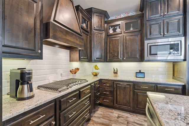 12505 Shady Gln, Choctaw, OK 73020 - kitchen with appliances with stainless steel finishes, premium range hood, decorative backsplash, and dark brown cabinets
