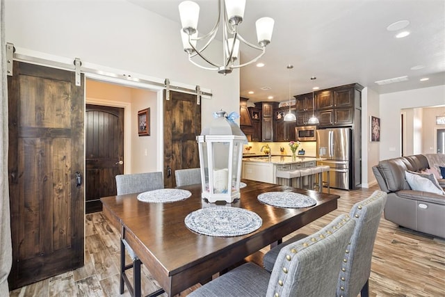 12505 Shady Gln, Choctaw, OK 73020 - dining area with a barn door, light wood finished floors, recessed lighting, and a chandelier