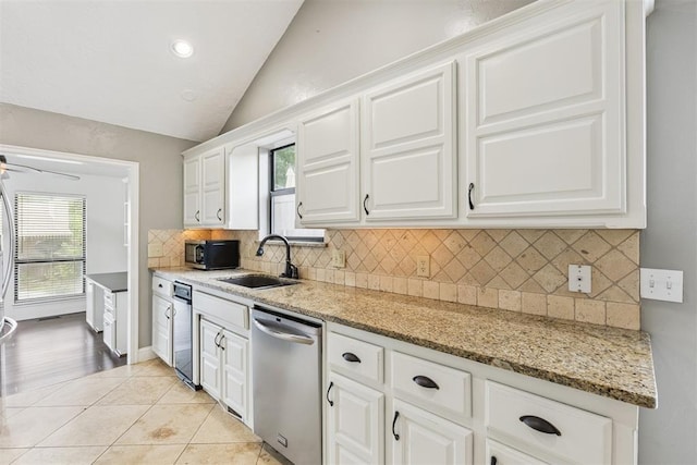 2416 Chimney Hill Ct, Edmond, OK 73034 - kitchen featuring stainless steel dishwasher, black microwave, lofted ceiling, white cabinets, and backsplash