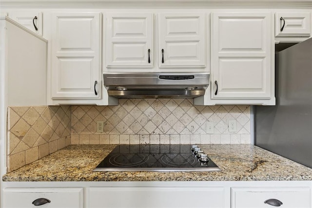 2416 Chimney Hill Ct, Edmond, OK 73034 - kitchen featuring black electric cooktop, under cabinet range hood, white cabinetry, and tasteful backsplash