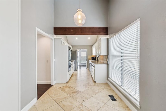 2416 Chimney Hill Ct, Edmond, OK 73034 - kitchen featuring light countertops, white cabinets, decorative backsplash, light tile patterned flooring, and beam ceiling