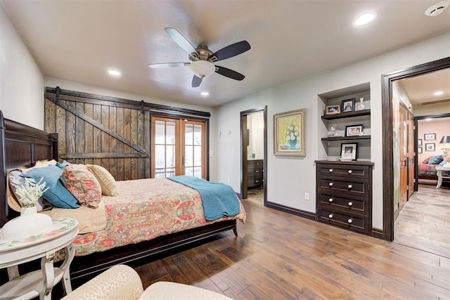 4225 Red Bud Pl, Edmond, OK 73013 - bedroom featuring a barn door, hardwood / wood-style flooring, ceiling fan, recessed lighting, and ensuite bathroom