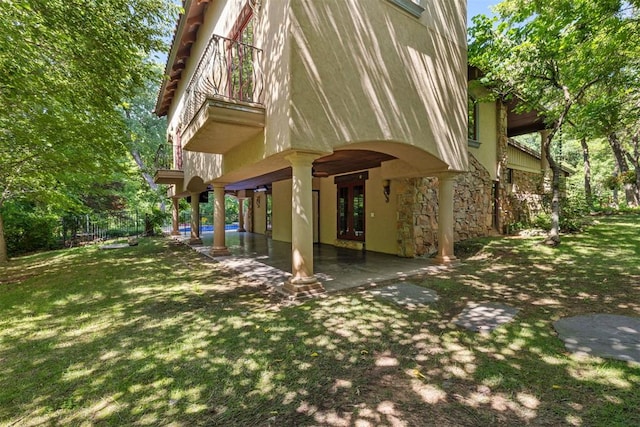 4225 Red Bud Pl, Edmond, OK 73013 - back of house with a patio area, stone siding, and a lawn