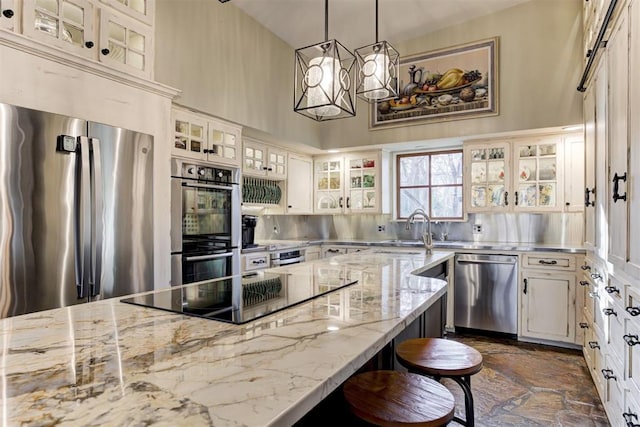 4225 Red Bud Pl, Edmond, OK 73013 - kitchen with stainless steel countertops, stainless steel appliances, a high ceiling, a kitchen breakfast bar, and dark stone finish floors