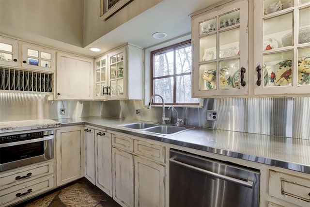 4225 Red Bud Pl, Edmond, OK 73013 - kitchen with stainless steel countertops, stainless steel appliances, and glass insert cabinets