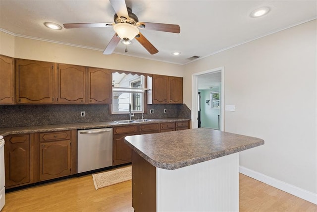 1623 W Washington Ave, Guthrie, OK 73044 - kitchen with stainless steel dishwasher, light wood-style flooring, backsplash, dark countertops, and ceiling fan