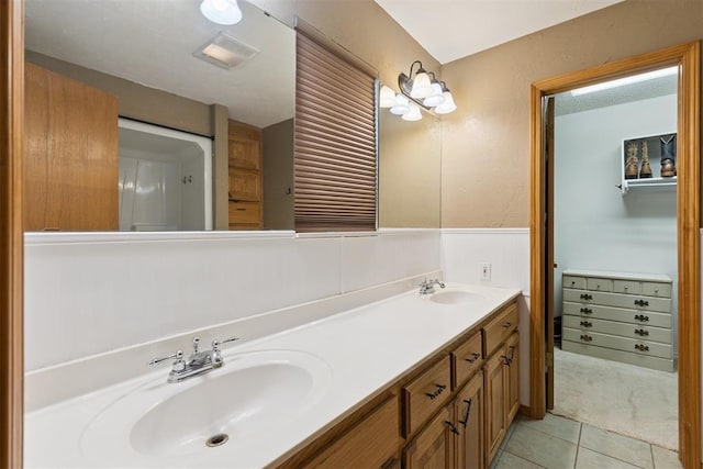 1623 W Washington Ave, Guthrie, OK 73044 - bathroom featuring double vanity, wainscoting, and tile patterned flooring