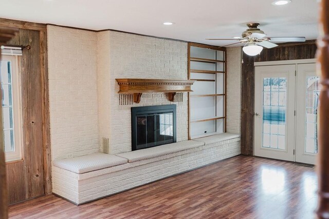 503 N Sheb Wooley Ave, Erick, OK 73645 - unfurnished living room with wood walls, a ceiling fan, wood finished floors, a fireplace, and recessed lighting