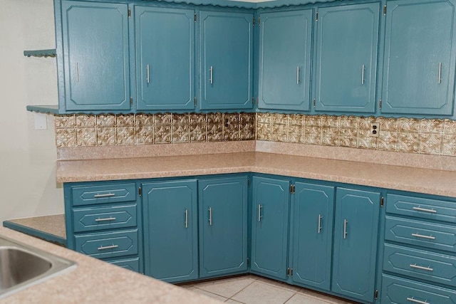 503 N Sheb Wooley Ave, Erick, OK 73645 - kitchen with light countertops, light tile patterned flooring, and blue cabinets