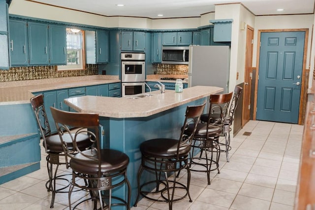 503 N Sheb Wooley Ave, Erick, OK 73645 - kitchen featuring stainless steel appliances, blue cabinetry, light countertops, and light tile patterned flooring