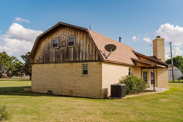 503 N Sheb Wooley Ave, Erick, OK 73645 - view of home's exterior with a gambrel roof, brick siding, a lawn, and a chimney