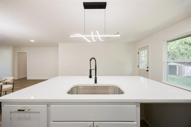 2020 Hasley Dr, The Village, OK 73120 - kitchen with light countertops, an island with sink, and wood finished floors