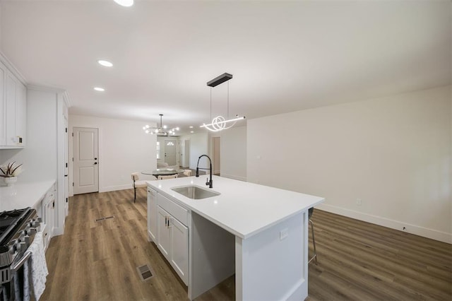 2020 Hasley Dr, The Village, OK 73120 - kitchen featuring dark wood-style floors, stainless steel range with gas stovetop, recessed lighting, an island with sink, and white cabinetry
