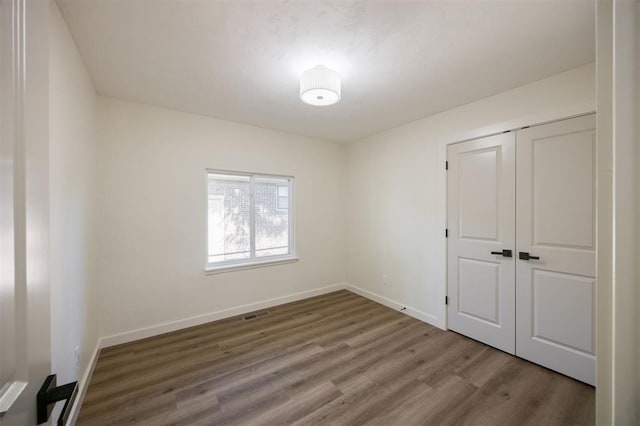 2020 Hasley Dr, The Village, OK 73120 - unfurnished bedroom featuring wood finished floors and a closet