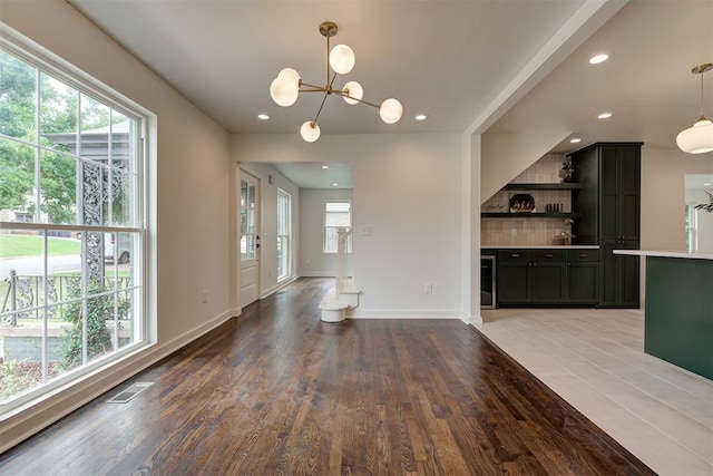 2836 NW 43rd St, Oklahoma City, OK 73112 - unfurnished living room featuring healthy amount of natural light, recessed lighting, light wood-type flooring, a chandelier, and beverage cooler
