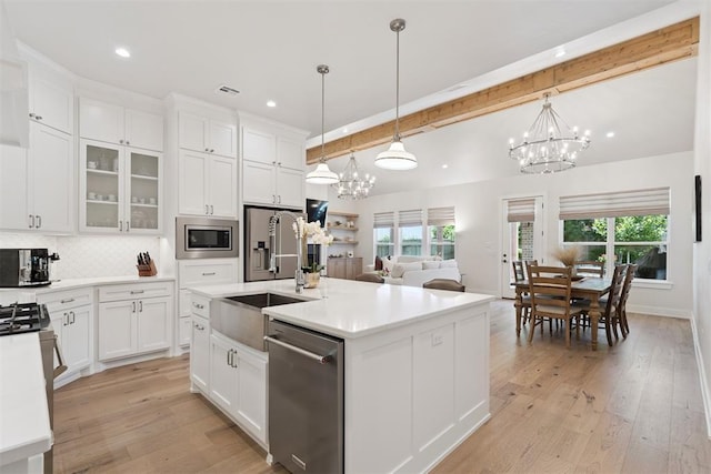 200 Pont Neuf Ct, Edmond, OK 73034 - kitchen featuring stainless steel appliances, a chandelier, beamed ceiling, white cabinets, and backsplash