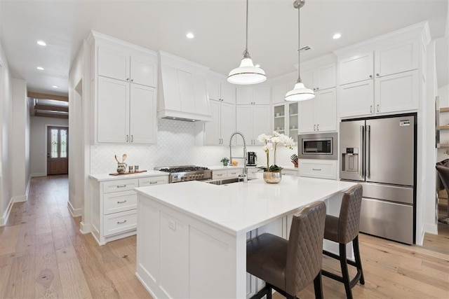 200 Pont Neuf Ct, Edmond, OK 73034 - kitchen featuring appliances with stainless steel finishes, custom range hood, tasteful backsplash, light wood-style floors, and recessed lighting