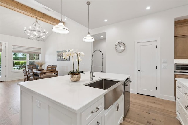 200 Pont Neuf Ct, Edmond, OK 73034 - kitchen with stainless steel dishwasher, light wood finished floors, recessed lighting, light countertops, and hanging light fixtures