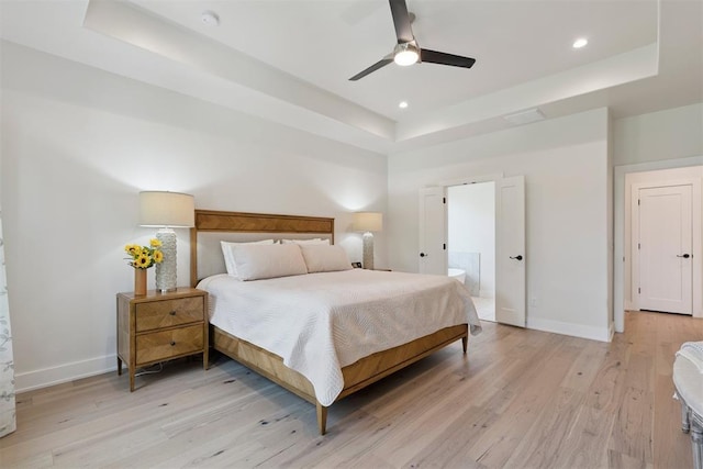 200 Pont Neuf Ct, Edmond, OK 73034 - bedroom with a tray ceiling, light wood-style flooring, connected bathroom, recessed lighting, and a ceiling fan