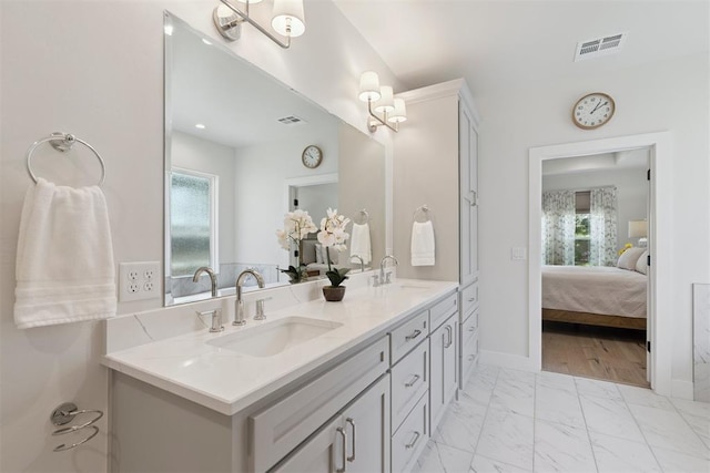 200 Pont Neuf Ct, Edmond, OK 73034 - ensuite bathroom with double vanity, plenty of natural light, and marble look tile flooring