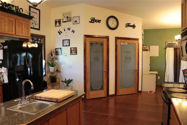 11800 Bryant Rd, Lexington, OK 73051 - kitchen with black appliances, dark countertops, brown cabinets, and dark tile patterned flooring