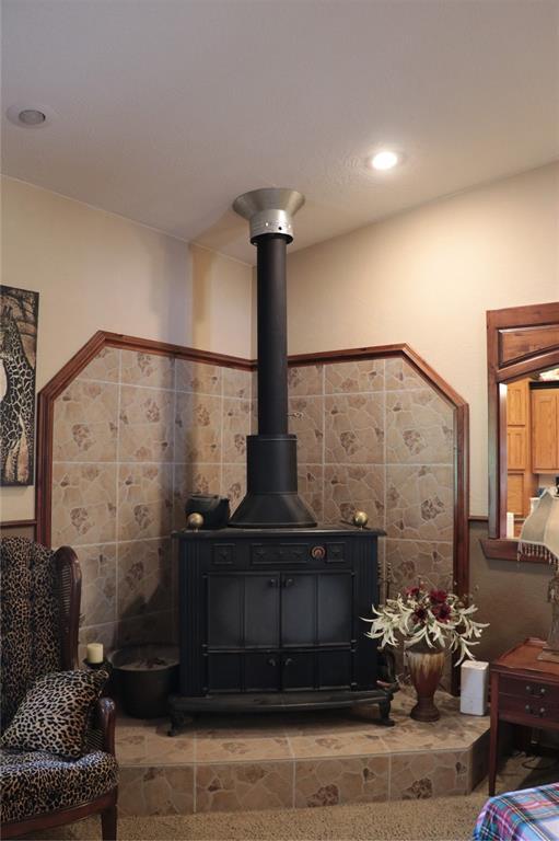 11800 Bryant Rd, Lexington, OK 73051 - detailed view of tile walls, wainscoting, and a wood stove