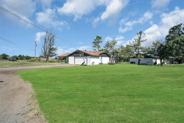 323 W 13th St, Snyder, OK 73566 - view of grassy yard with driveway and a garage