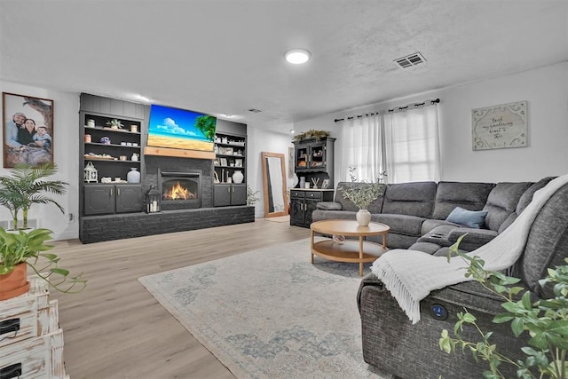 323 W 13th St, Snyder, OK 73566 - living area featuring a fireplace, built in features, and wood finished floors