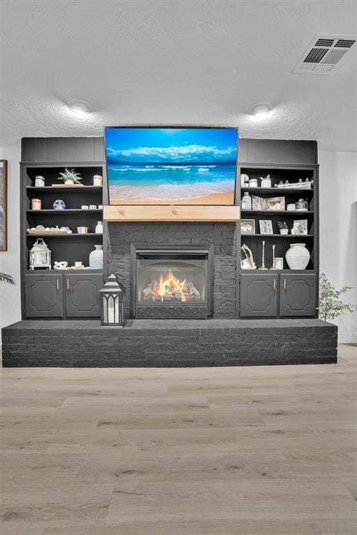 323 W 13th St, Snyder, OK 73566 - detailed view of wood finished floors, a fireplace, and built in shelves