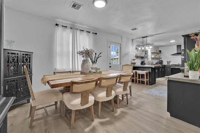 323 W 13th St, Snyder, OK 73566 - dining space with light wood-style floors and a textured ceiling
