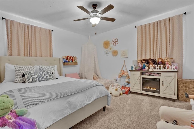 323 W 13th St, Snyder, OK 73566 - carpeted bedroom featuring a ceiling fan and a glass covered fireplace