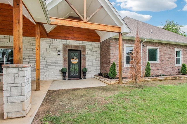 9228 E Cardinal Pl, Midwest City, OK 73130 - property entrance featuring brick siding, a lawn, and a shingled roof