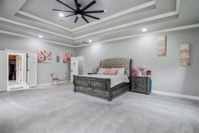 9228 E Cardinal Pl, Midwest City, OK 73130 - carpeted bedroom with a tray ceiling, crown molding, recessed lighting, ceiling fan, and a walk in closet